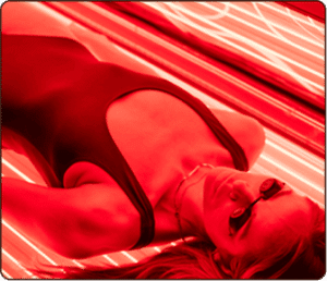 Woman lying in a red light therapy bed at The Tanning Shop UK – skin rejuvenation treatment