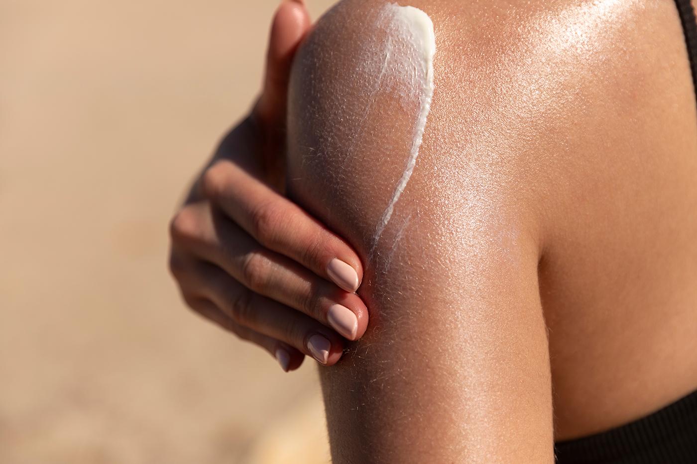 How to use a sunbed responsibly - woman applying sunscreen lotion before tanning at The Tanning Shop UK