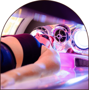 Close-up of a woman wearing protective eyewear while using a lay-down UV tanning bed.