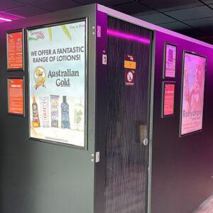 The Tanning Shop Castle Bromwich interior hallway with Australian Gold tanning lotion promotional posters