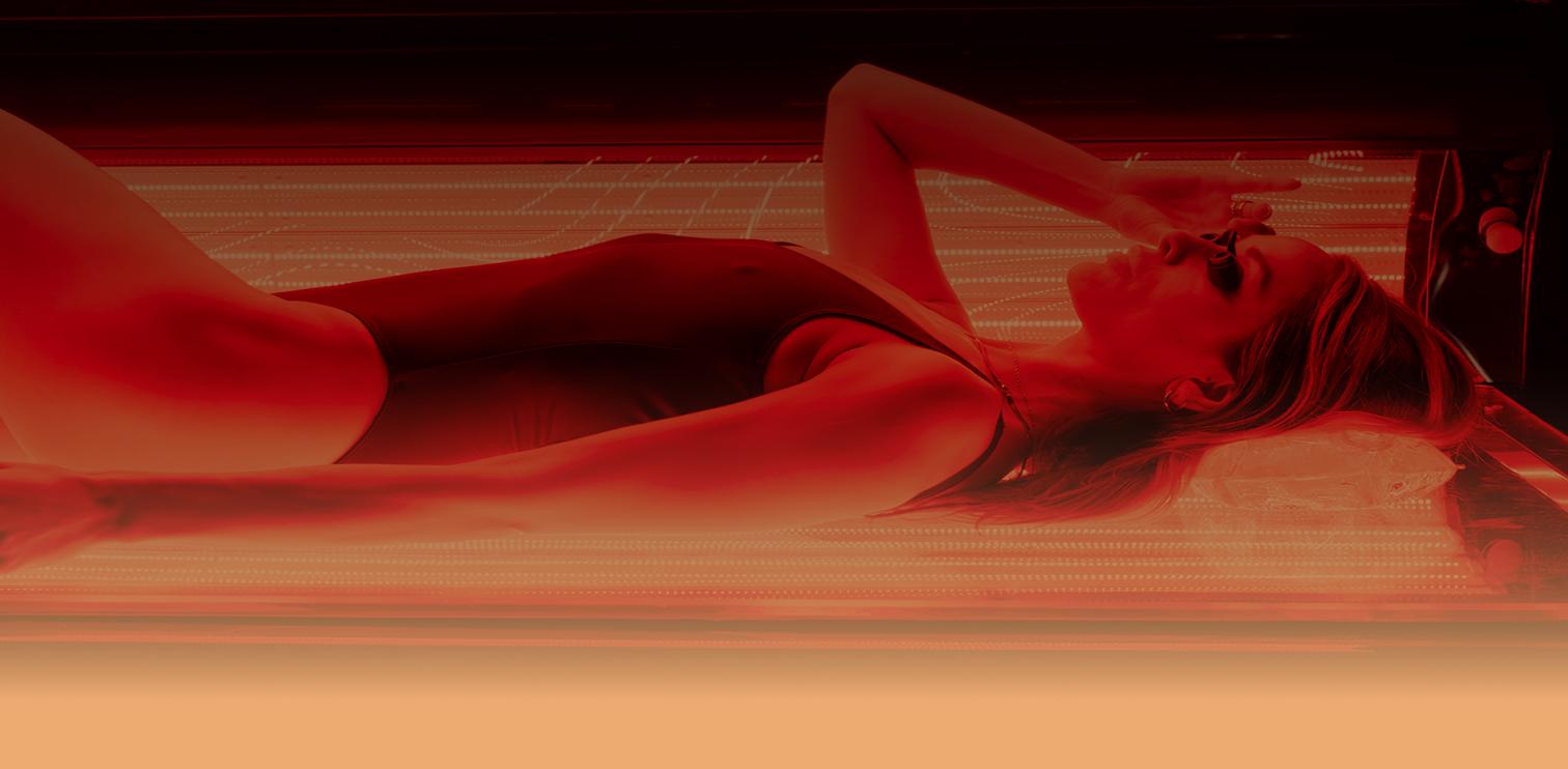 Woman relaxing in red light therapy bed at The Tanning Shop Oxford Circus