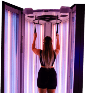 Woman using red light therapy booth