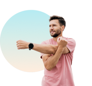 Man stretching his shoulder before a workout, highlighting red light therapy benefits for muscle recovery and joint pain relief at The Tanning Shop UK
