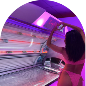 Content creator photographing a professional UV sunbed in a pink-lit tanning room at The Tanning Shop UK influencer programme