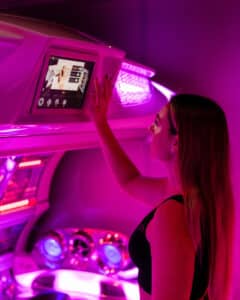 Customer using the touchscreen control panel on a state-of-the-art sunbed at The Tanning Shop UK