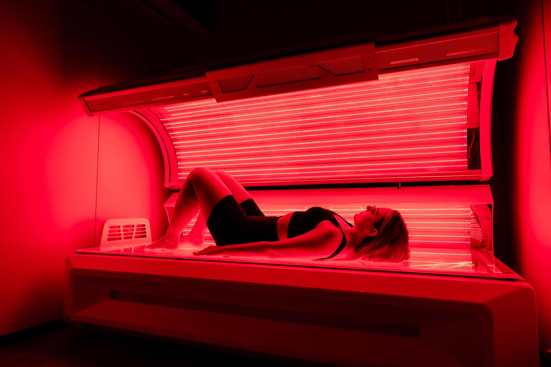Woman Red Light Therapy Bed Session Collagen Skin Rejuvenation The Tanning Shop Woman lying in a full-body red light therapy bed during a skin rejuvenation and wellness session at The Tanning Shop UK